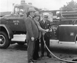 Two firemen with the fire chief looking at the new fire truck at the Dundas Street station. Belle...